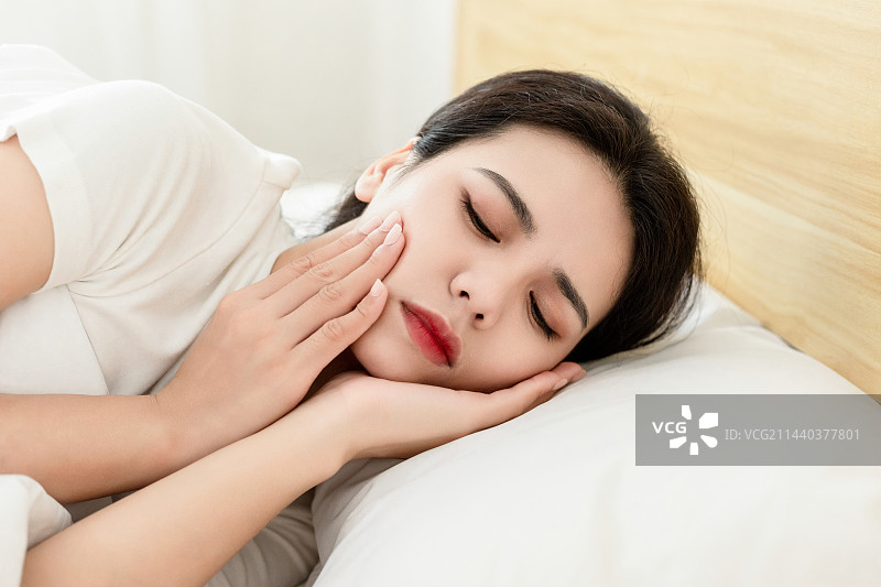 一名牙齿疼痛的中国年轻女人图片素材