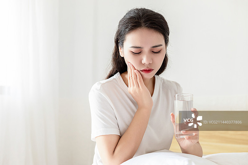 一名牙齿疼痛的中国年轻女人图片素材