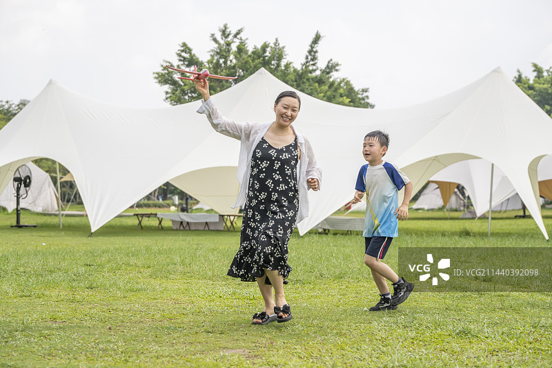夏天公园露营帐篷前互动的妈妈和孩子图片素材