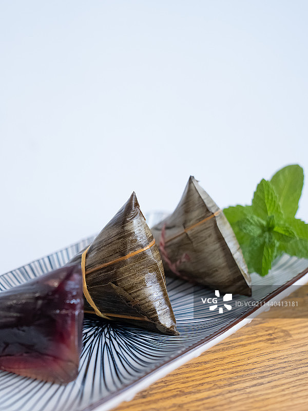 蓝色条纹盘子上的水晶粽子和薄荷图片素材