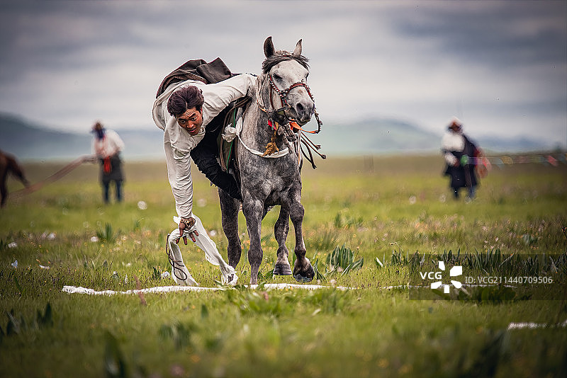 甘南藏族自治州玛曲县骑在马上捡哈达的藏族人图片素材