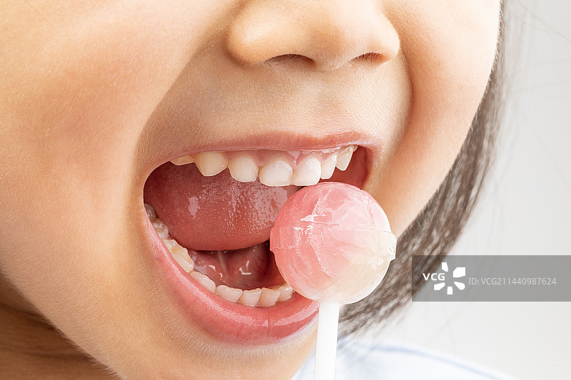 正在吃棒棒糖的小女孩图片素材