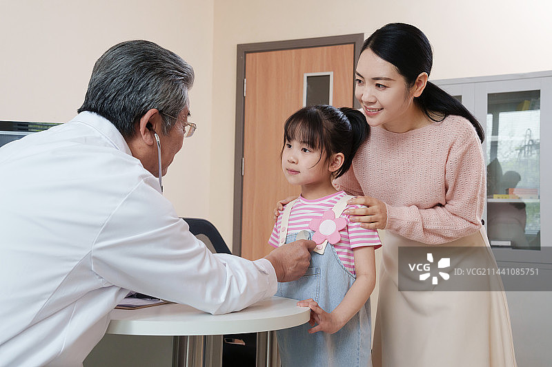 年轻妈妈带着孩子看医生图片素材