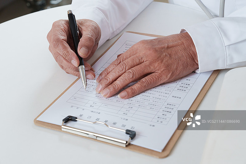 老年男医生写病历图片素材
