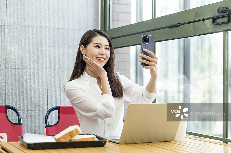 年轻商务女士在咖啡厅视频电话图片素材