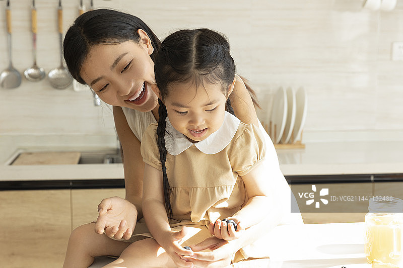 快乐母女在开敞厨房嬉戏图片素材