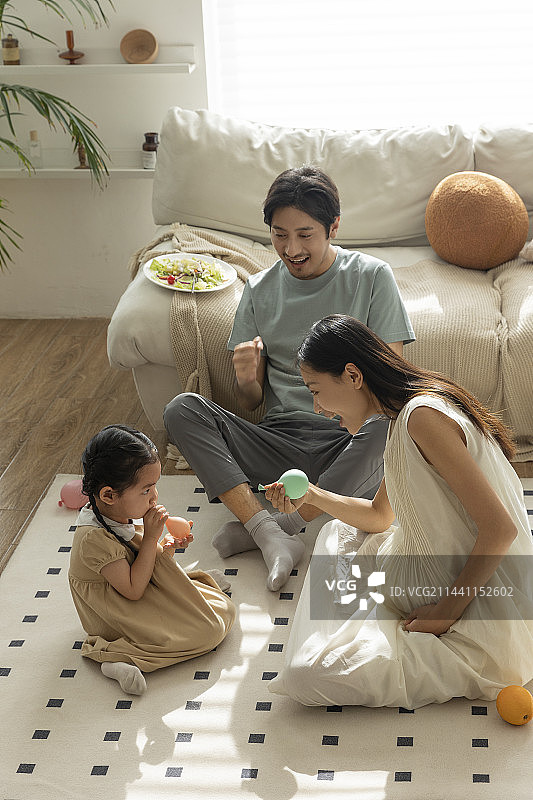 幸福一家人在客厅吹气球嬉戏玩耍图片素材