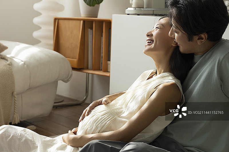 丈夫和怀孕妻子在客厅休息嬉戏图片素材