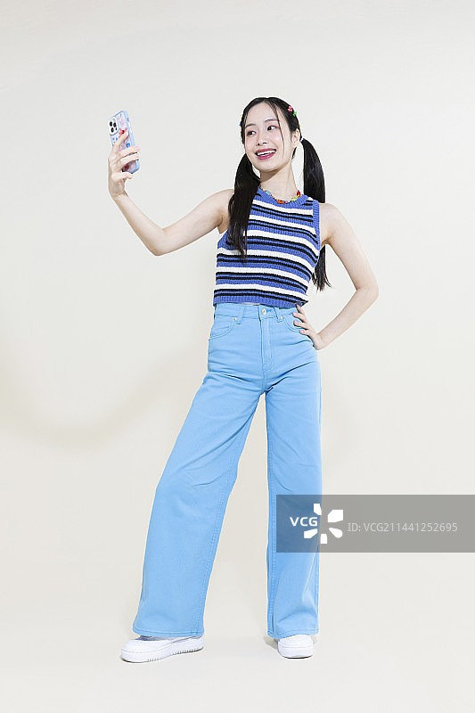 Y2K粉色复古概念照片：手持智能手机的亚洲女性图片素材