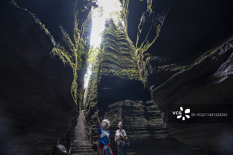 夏日两位美女大学生在湖北恩施梭布垭石林风景区一线天景点游玩图片素材