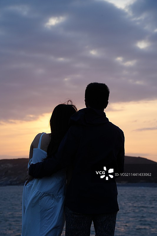 福州东甲岛 傍晚在礁石上看日落的拥抱的情侣图片素材