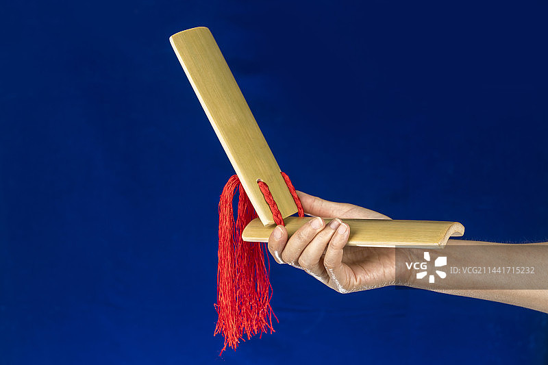 身穿大褂的曲艺演员正在演奏快板书特写图片素材