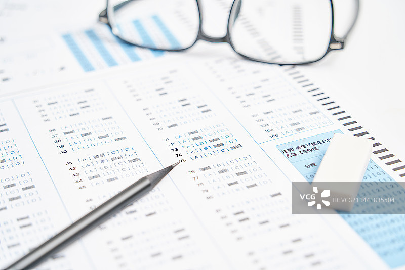 考试答题卡上放着一支笔和眼镜图片素材