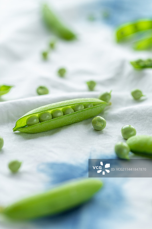 放在白色的布上新鲜豌豆特写图片素材