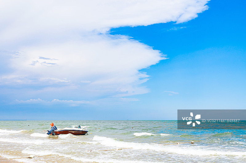 海边停泊着一只红白相间的快艇图片素材