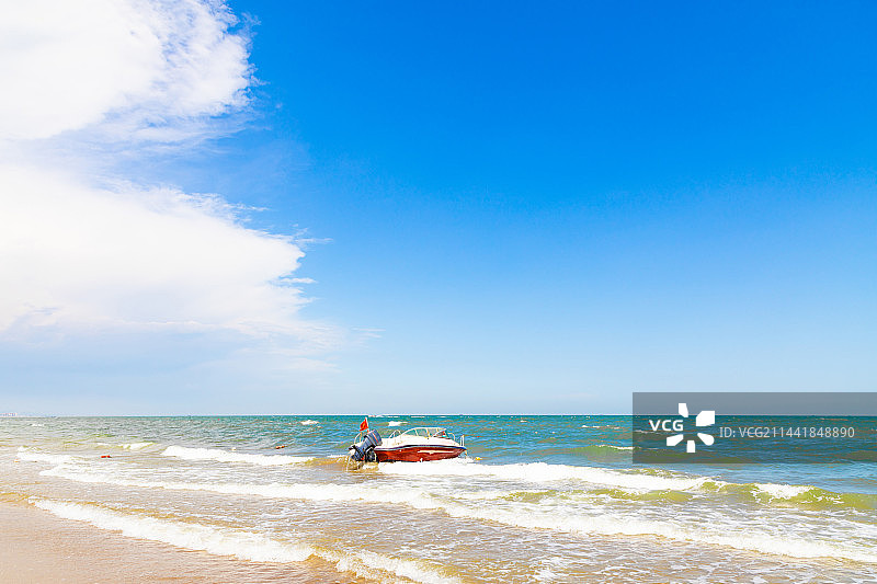 海边停泊着一只红白相间的快艇图片素材