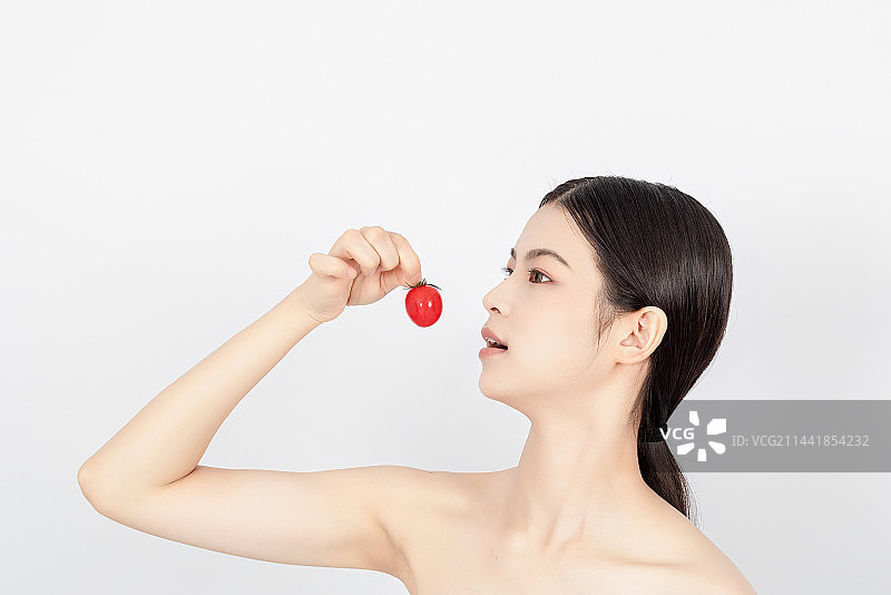 美容护肤概念一名亚洲美女手拿着圣女果图片素材