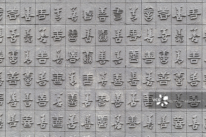 一面刻着各种字体善字的砖墙图片素材