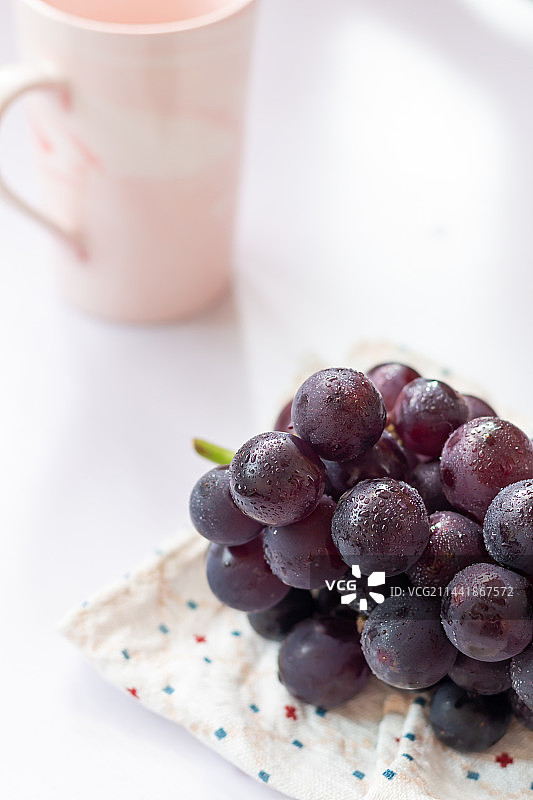 白色背景亮调的紫黑色水果葡萄静物图片素材