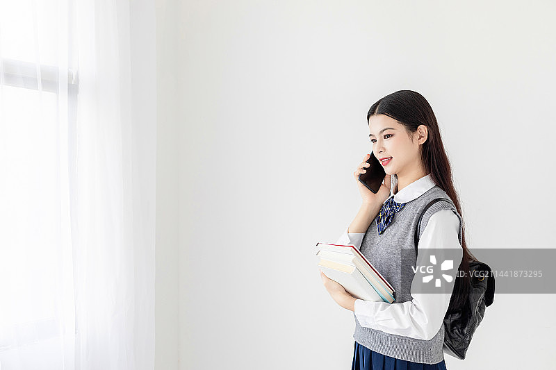 室内使用手机的中国大学生图片素材