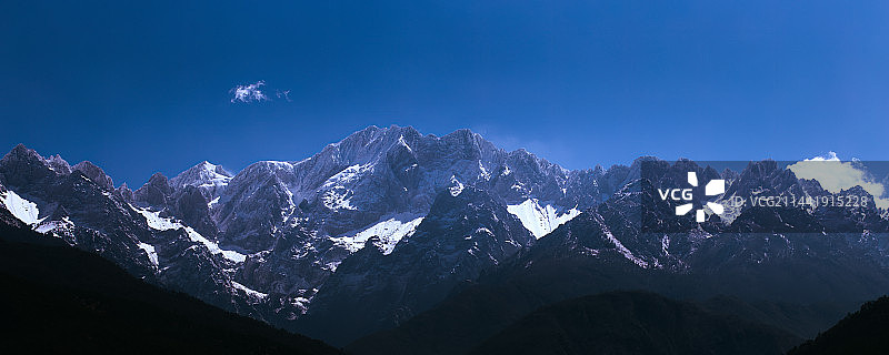 蓝天下白雪皑皑的玉龙雪山群山全景图片素材
