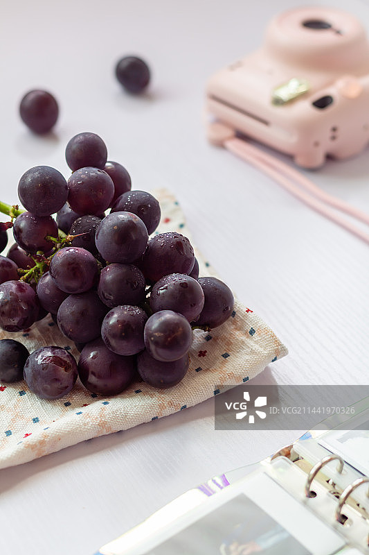 白色背景亮调的紫黑色水果葡萄静物图片素材