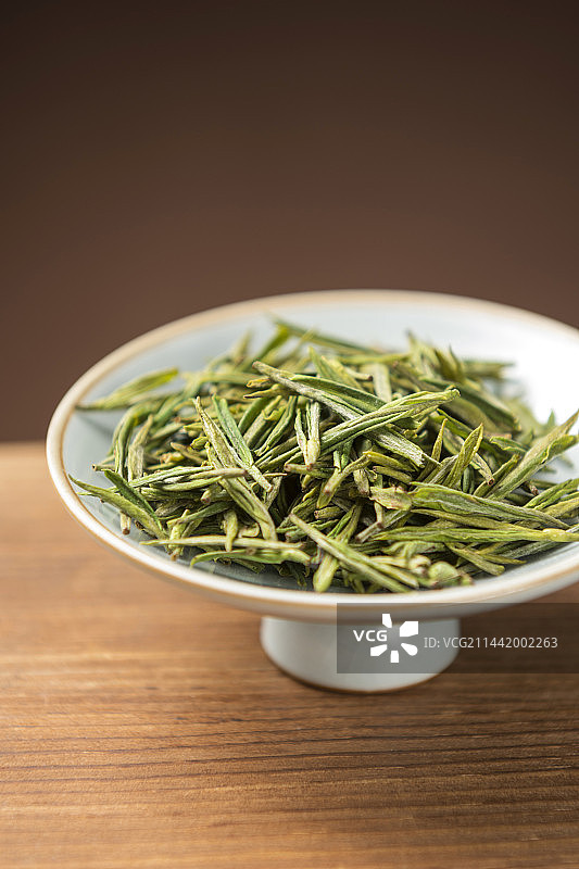 一盘白茶摆放在木桌面上特写图片素材