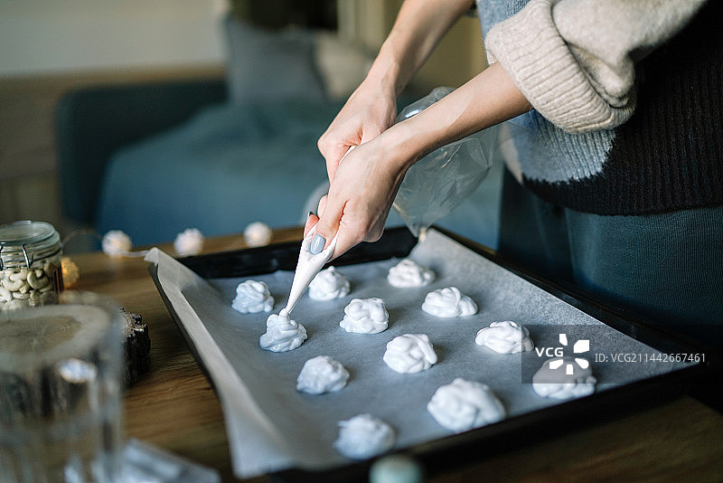 女性在西班牙家中制作蛋白酥皮的局部特写图片素材