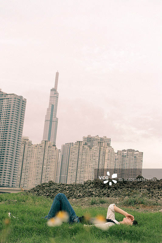 越南草地上放松的年轻男人侧视图图片素材