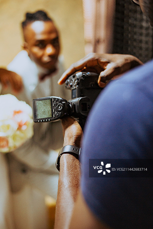 男性摄影师在白色工作室拍摄情侣的后视图图片素材