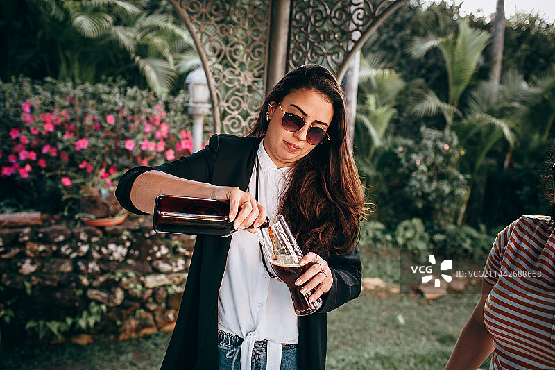 朋友在桌旁举杯庆祝，户外野餐，巴西米纳斯吉拉斯州贝洛奥里藏特图片素材