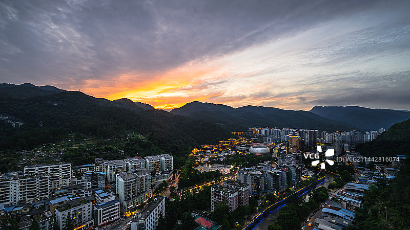 重庆市酉阳土家族苗族自治县 城北城市建筑群桃花源景区桃花源广场酉州古城夜日落时城市建筑物的高角度俯视图片素材