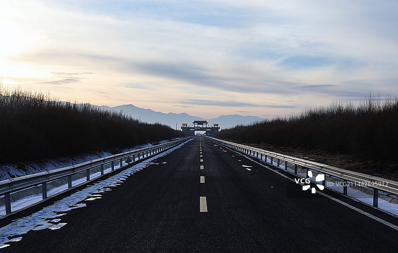 甘肃嘉峪关黄昏时分在马路上遥望长城第一墩景区关城城门图片素材
