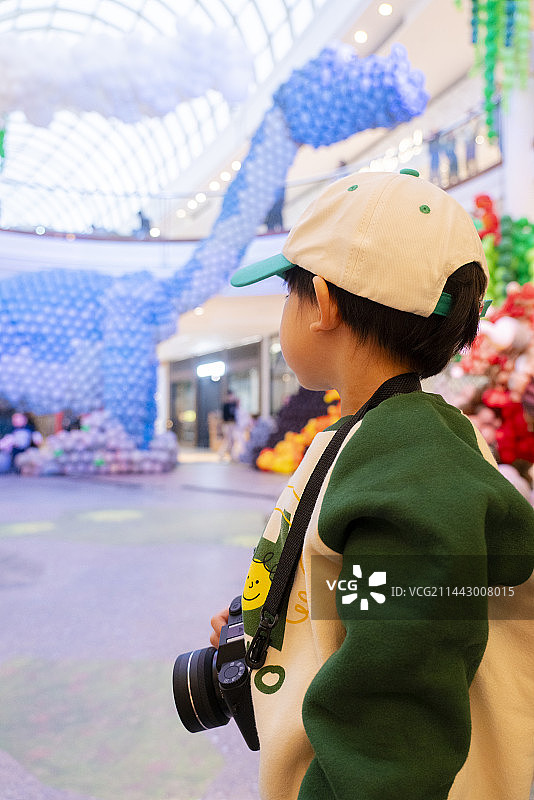 购物中心恐龙气球与小男孩摄影师图片素材