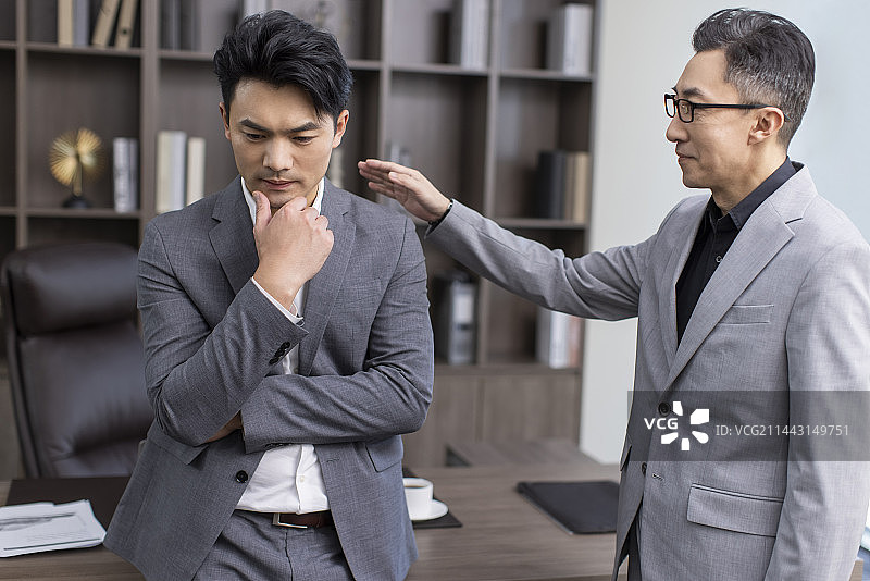 Businessman consoling his colleague图片素材