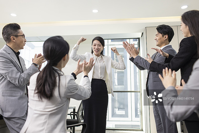 Cheerful business people applauding in office图片素材