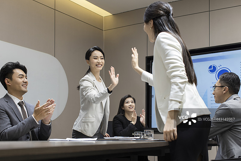 Cheerful business people celebrating in meeting room图片素材