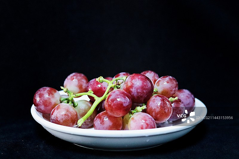 黑色背景下碗中葡萄的高角度视图图片素材