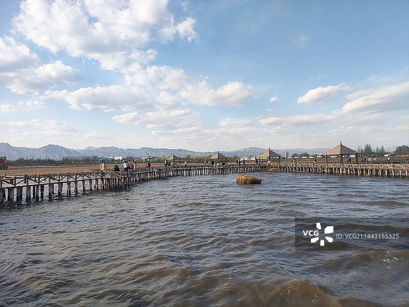 多云的天空衬托着内蒙古呼和浩特土左旗哈素海湖泊水上栈桥的景色图片素材