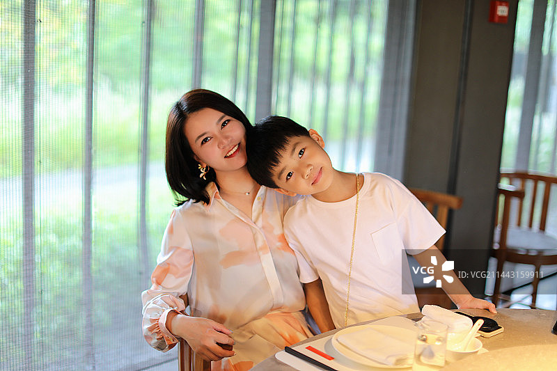 年轻的母亲和她的孩子在餐厅里图片素材