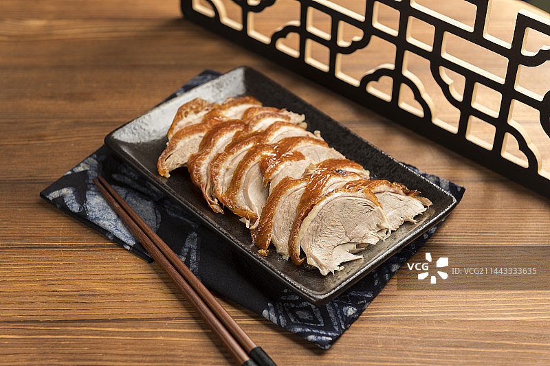 传统美食特色名菜烤鸭摆放在木桌面上特写图片素材