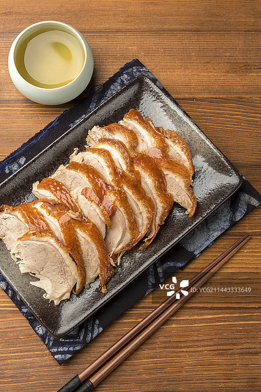 传统美食特色名菜烤鸭摆放在木桌面上特写图片素材