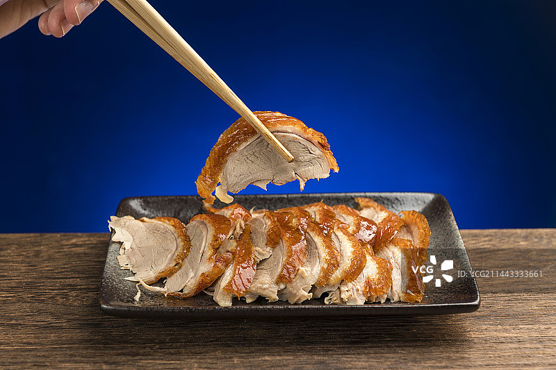 传统美食特色名菜烤鸭摆放在木桌面上特写图片素材
