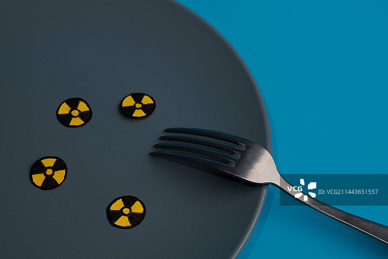 放在灰色盘子中的圆形放射符号和餐具微缩创意图片素材