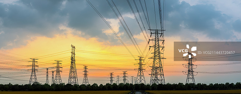 高压电力塔和自然风光在夏季日落时图片素材