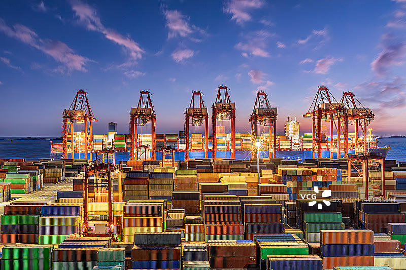 大型集装箱港口堆叠的集装箱和起重机夜景图片素材