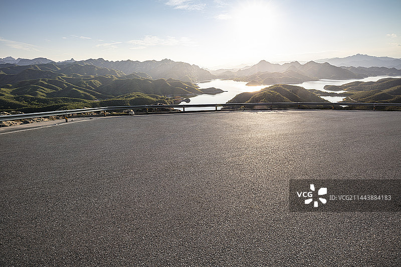 山路柏油路停车场平台，远眺群山湖泊日出图片素材