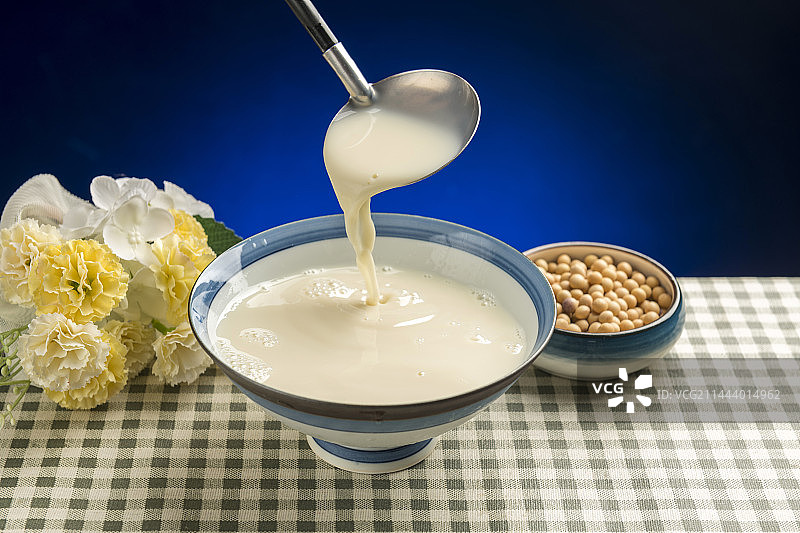 用勺子盛豆浆特写木桌面格子桌布背景图片素材