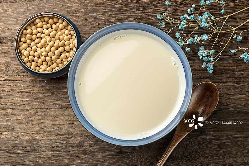 用勺子盛豆浆特写木桌面格子桌布背景图片素材