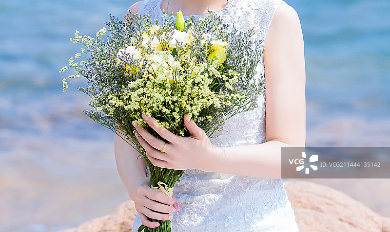 海边一位手捧鲜花的美女特写图片素材